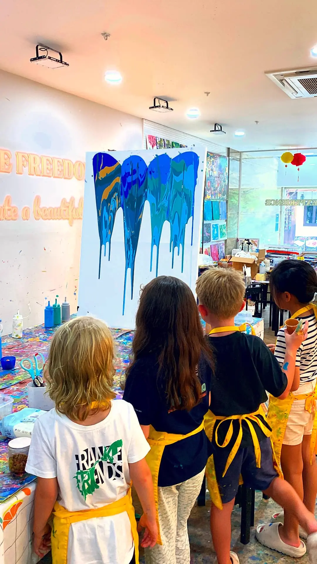 Campers watching a giant drip painting dry at Blank Space Studio