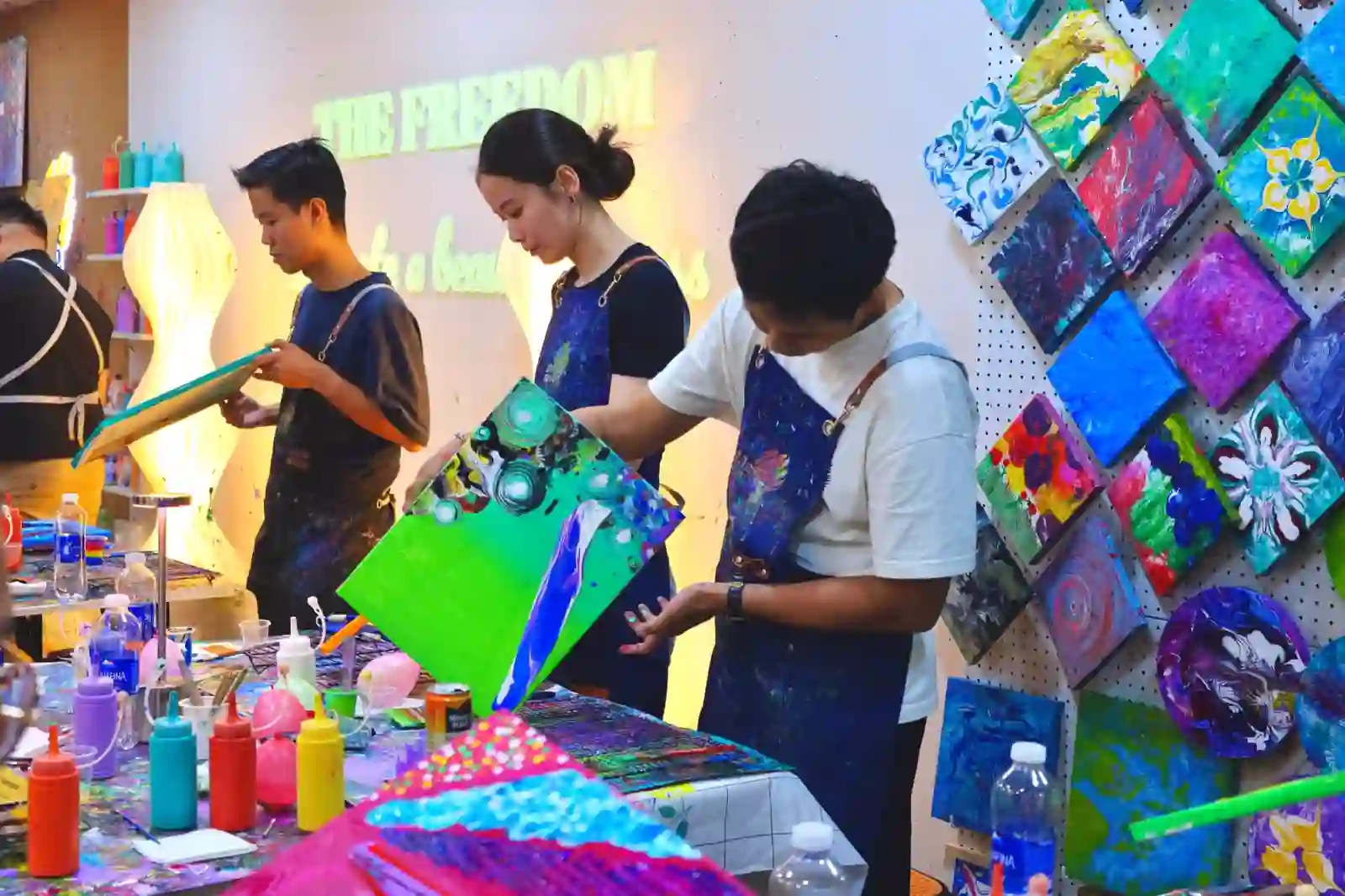Colleagues creating fluid art canvases together at a team bonding session at Blank Space Studio