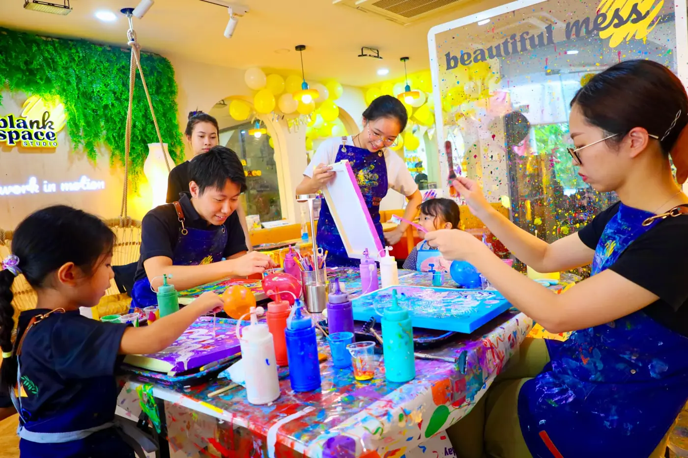 Parents and children pouring paint together at Blank Space Studio