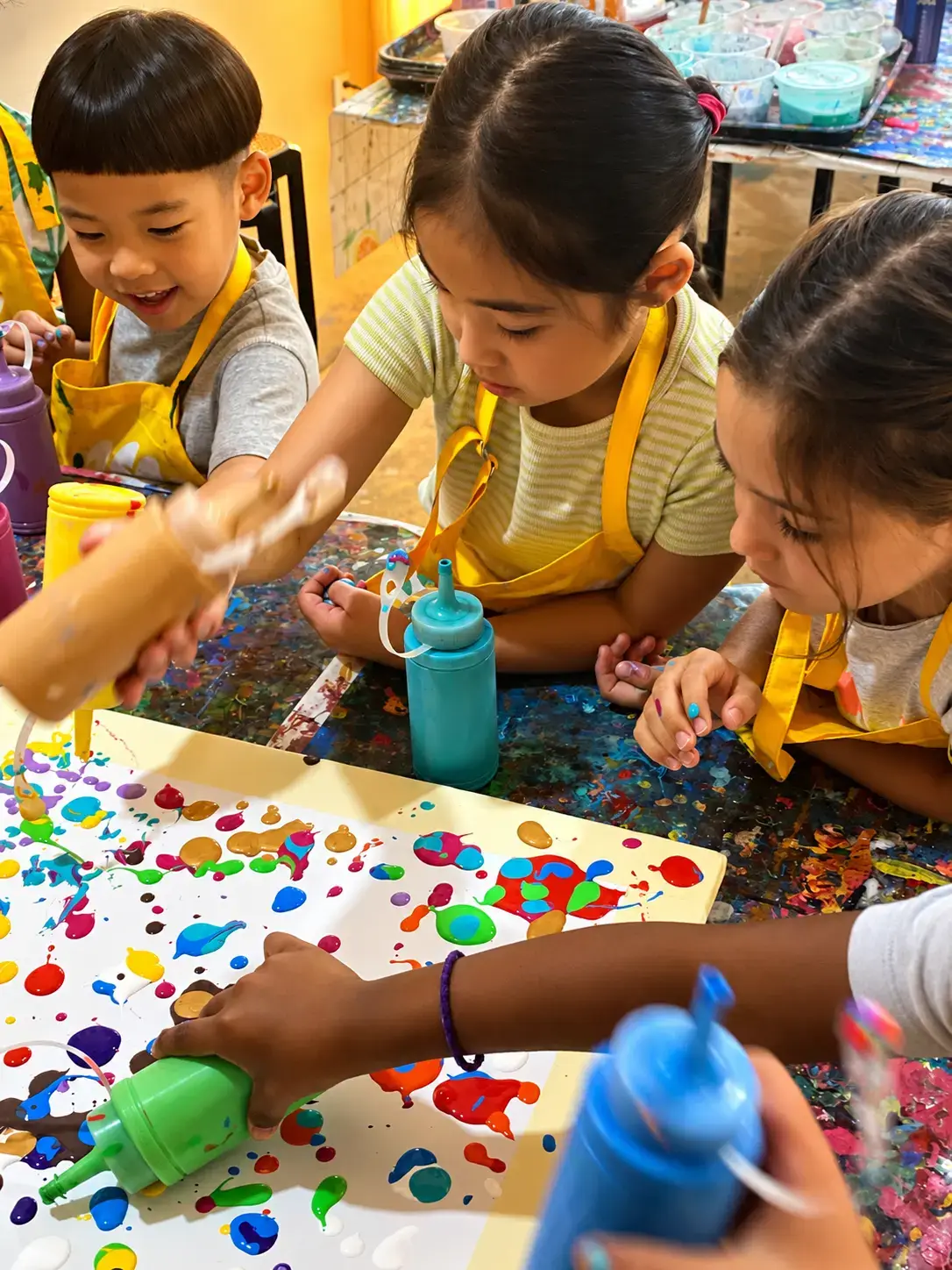 Kids squeezing paint bottles onto a shared canvas at camp