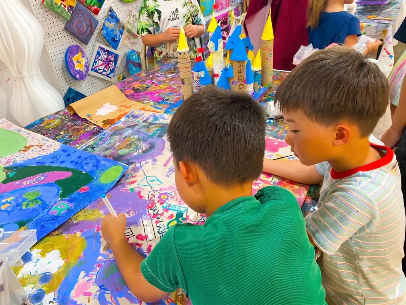 Kids painting a collaborative mural at an art camp in Saigon