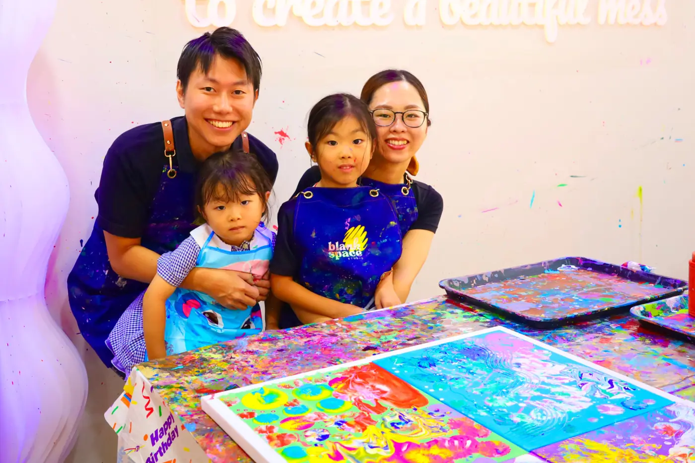 Family posing with their finished fluid art canvases