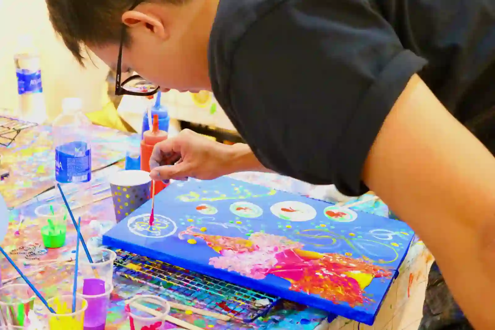Team member painting his individual canvas at a team bonding workshop in Ho Chi Minh City