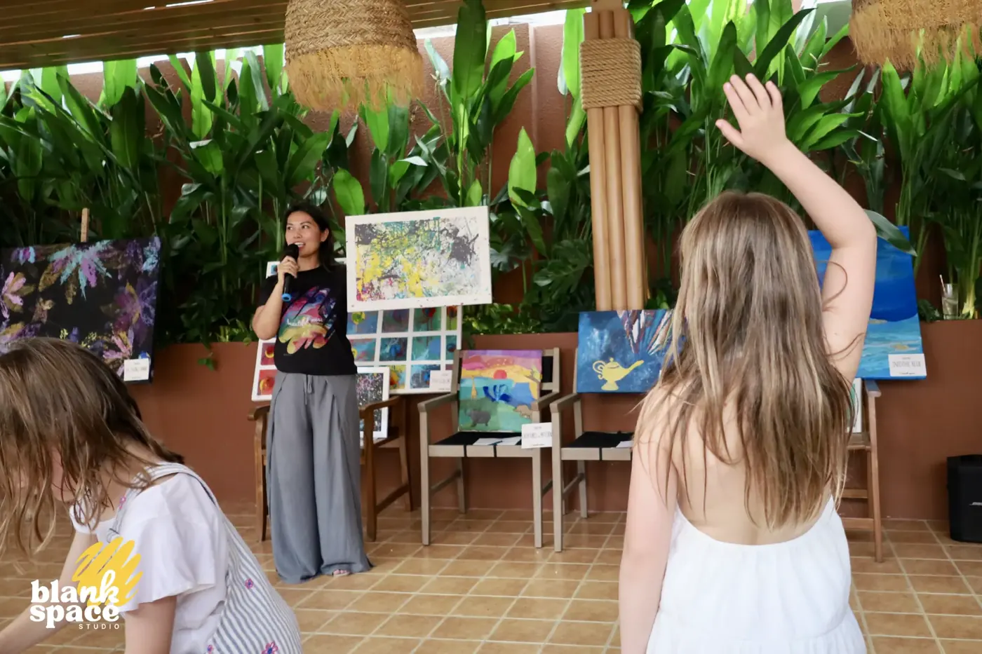 Host presenting camp artwork to families at the charity art auction
