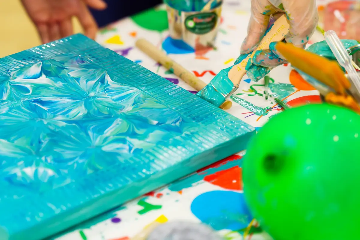 Guest-created teal textured canvas from a paint pouring class in Saigon