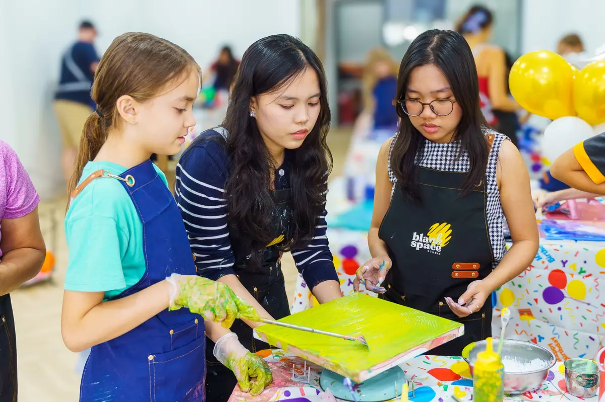 Bright yellow paint pour canvas from an art session near Thao Dien