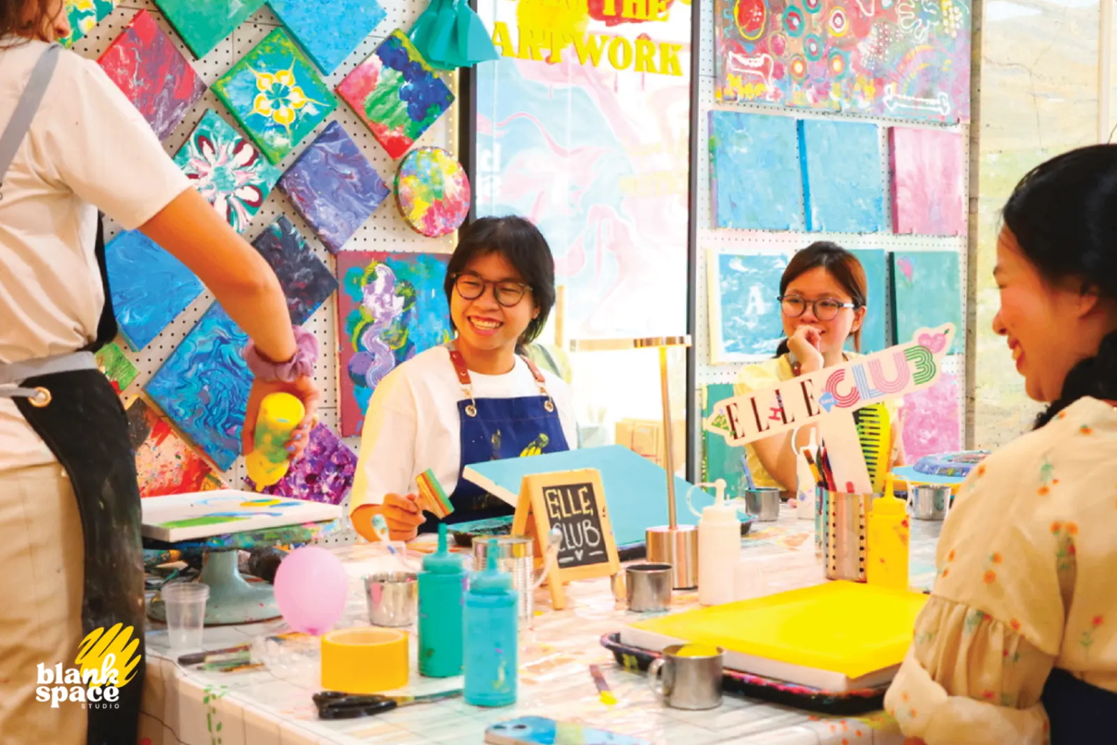Team bonding guests smiling around the painting table in Saigon
