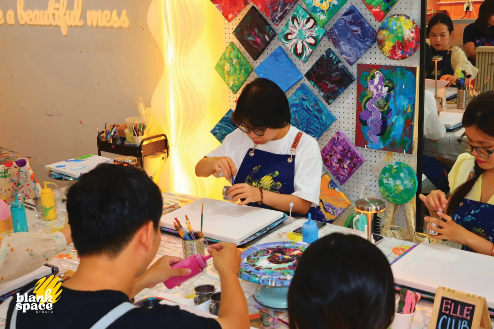 Team bonding participants painting together in the Blank Space Studio workshop
