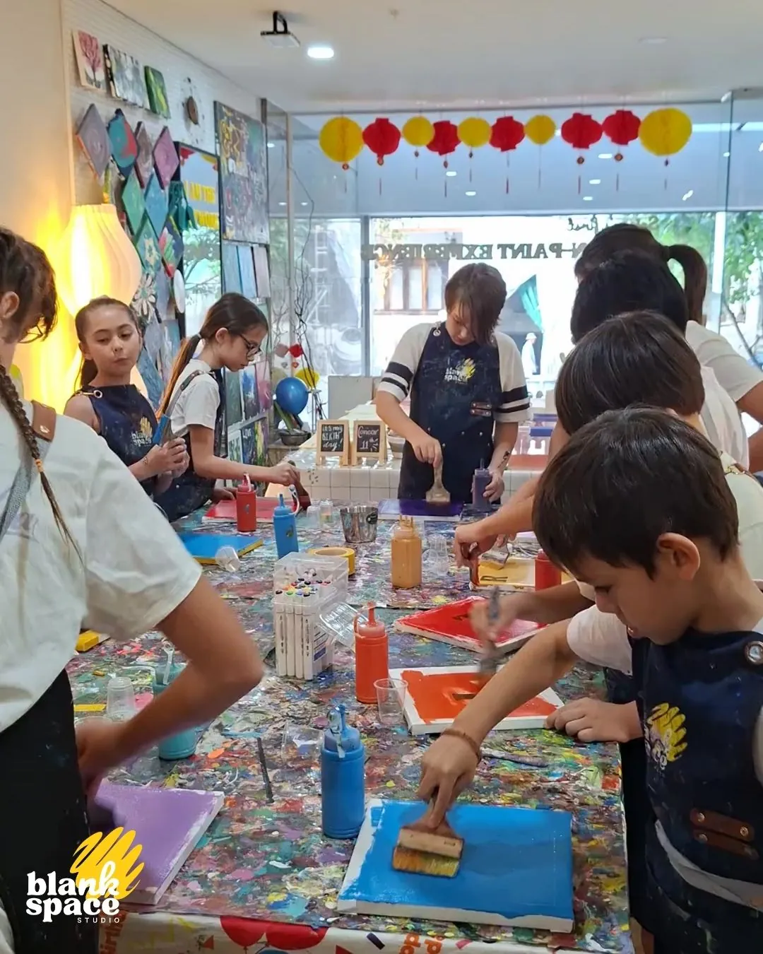 Children painting with brushes at a birthday camp activity in Saigon