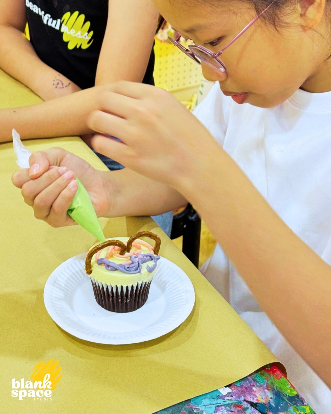 Girl decorating a cupcake at a birthday party at Blank Space Studio Saigon
