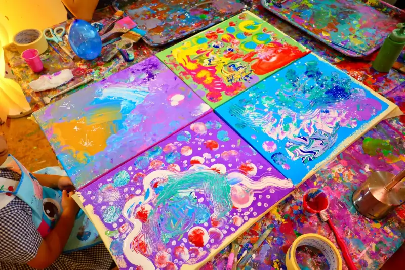 Four finished fluid art canvases from a kids art activity in Saigon