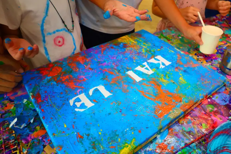Splatter painted canvas with a child's name stencilled in white