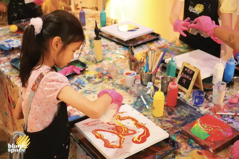 Girl creating canvas art at a kids birthday party in Saigon