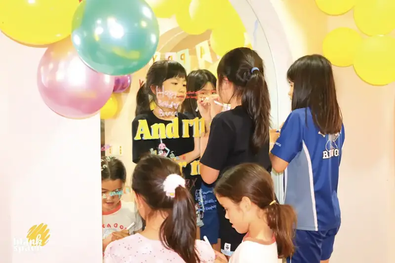 Kids writing on mirror during a creative birthday party in Saigon
