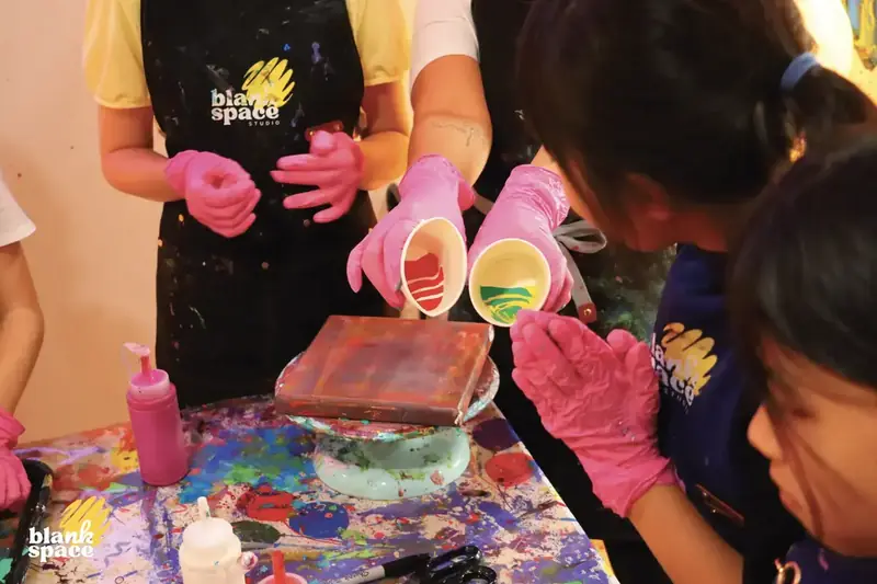Guided paint pouring activity at a kids birthday party near Thao Dien