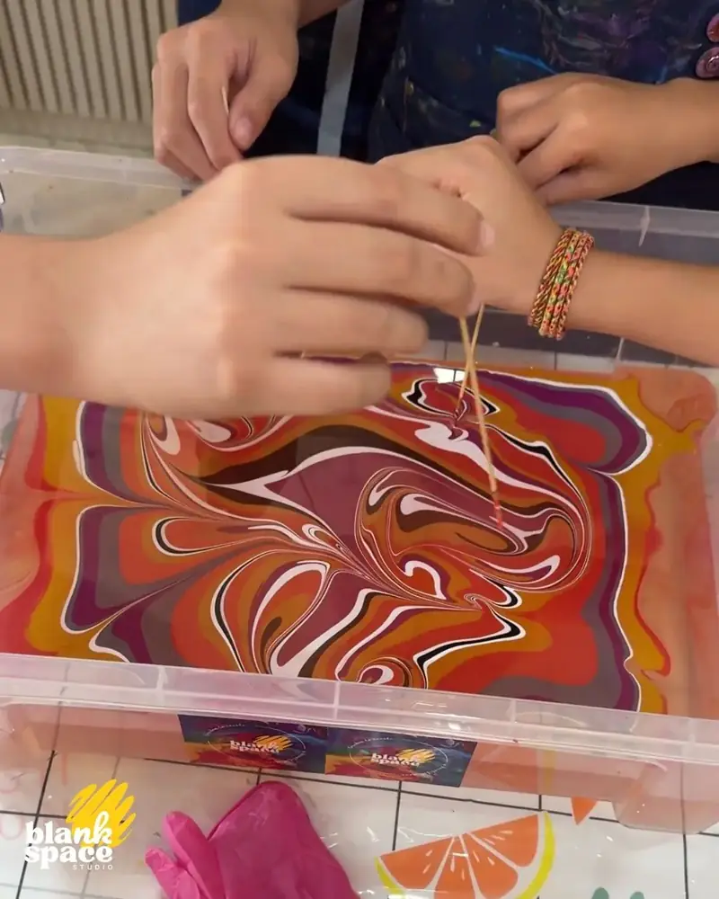 Kids doing water-marbling art at a birthday experience in Ho Chi Minh City