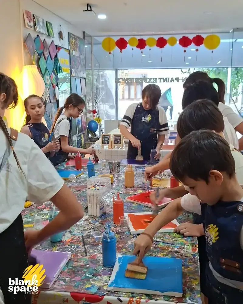 Children painting with brushes at a birthday camp activity in Saigon