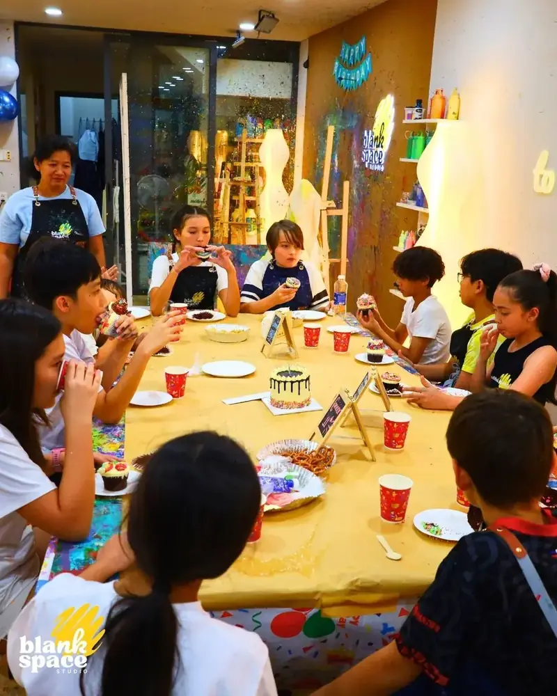 Kids eating cupcakes at a birthday celebration table at Blank Space Studio HCMC