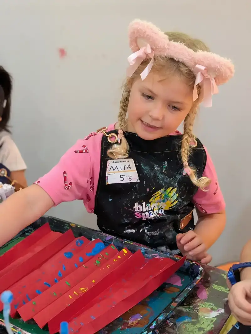Girl with cat ears and fan at a kids art workshop in Ho Chi Minh City