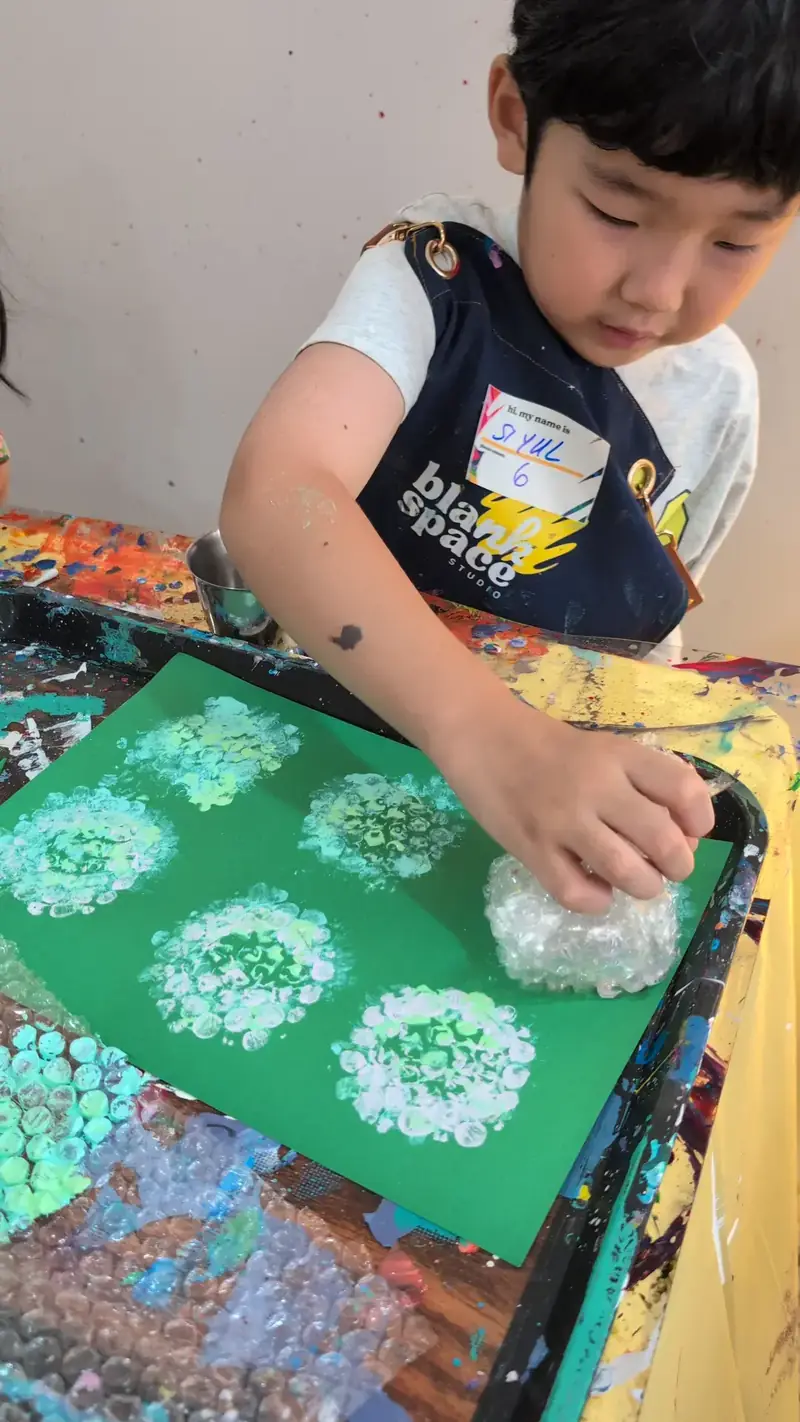 Boy bubble wrap stamping at an art class for kids in Saigon