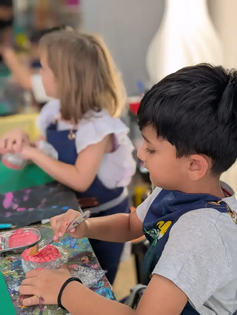 Kids crafting with stamps at a creative holiday camp near Thao Dien