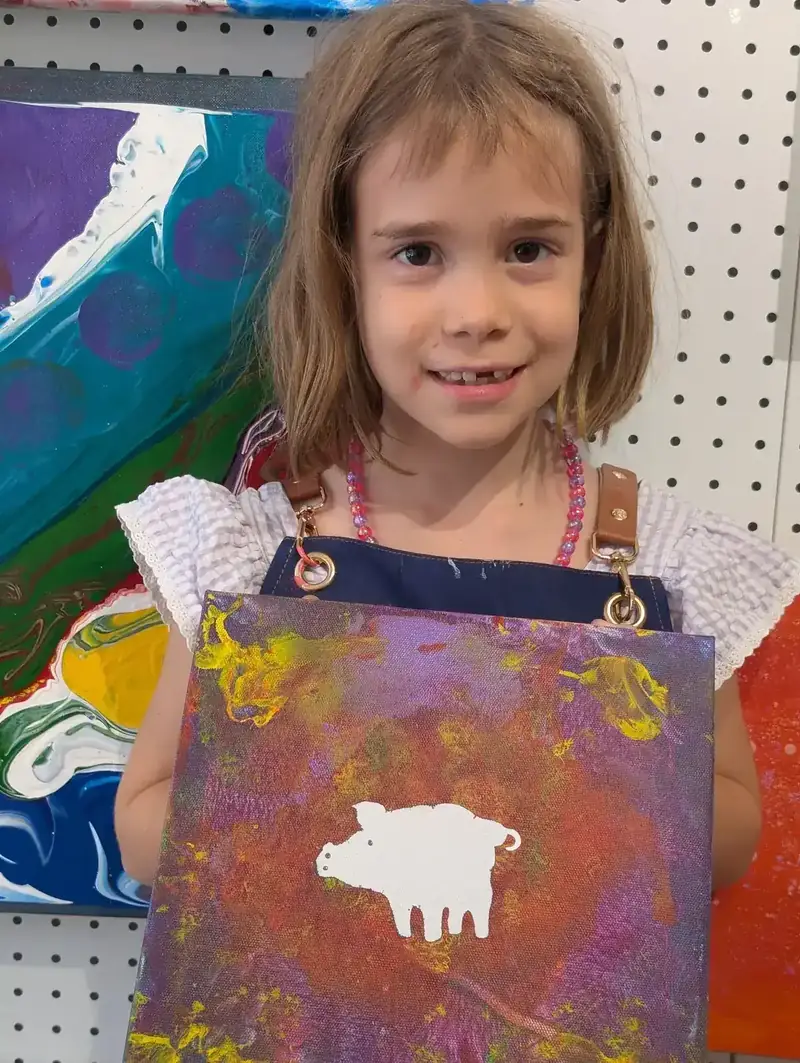 Girl holding pig stencil canvas at a holiday camp in Saigon