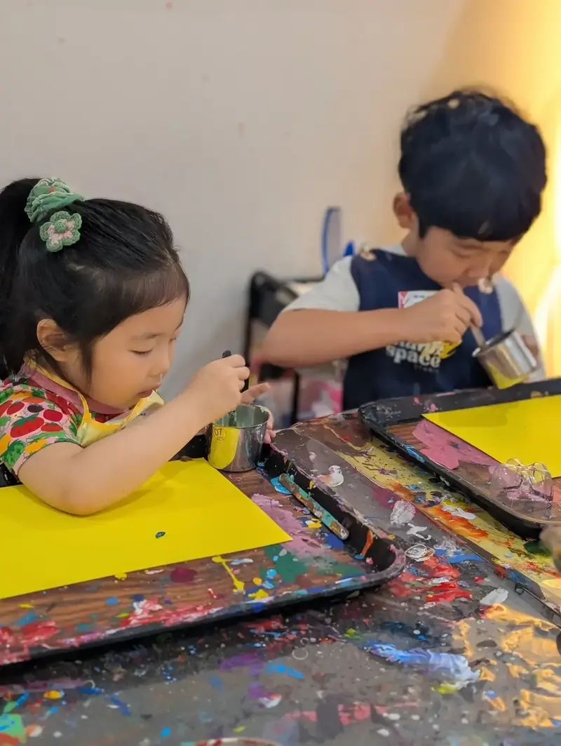 Kids mixing paint at a holiday camp activity in HCMC