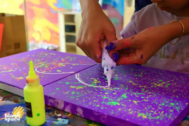 Friends making a connected splatter canvas at Blank Space Studio Saigon