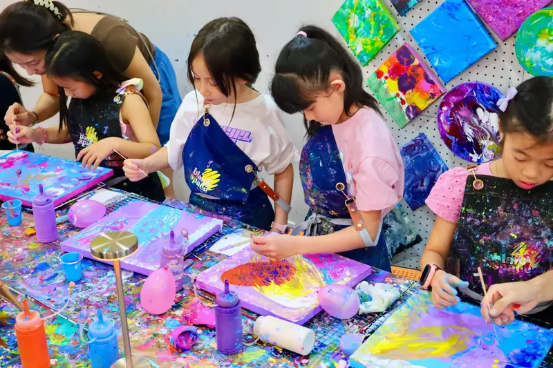 Kids painting canvases together at a creative celebration in Saigon