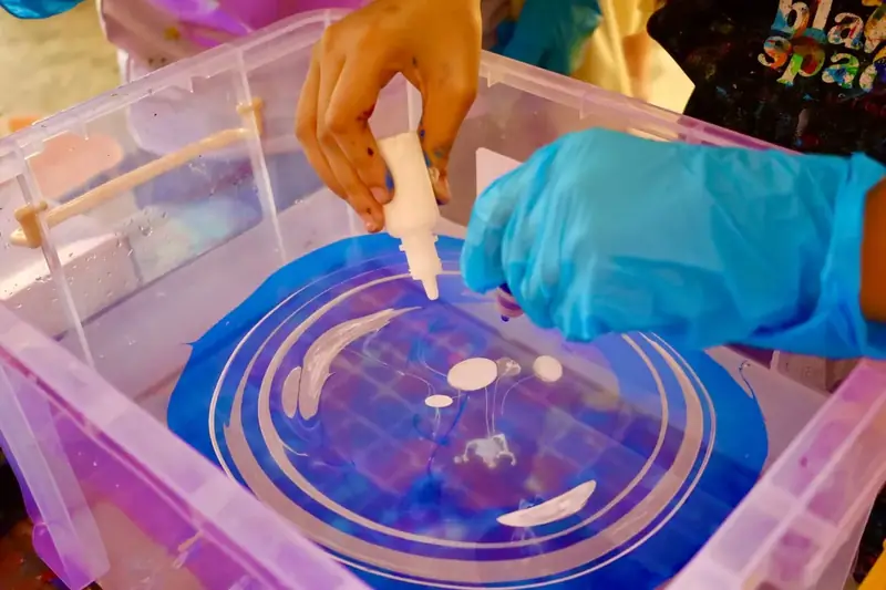 Making marbled patterns in a water tray at a creative celebration in Saigon