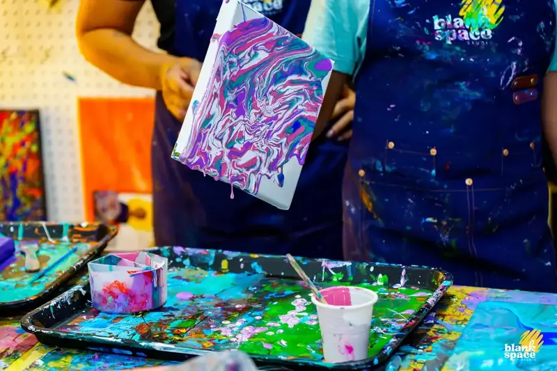 Purple and pink paint pour artwork created at Blank Space Studio Saigon