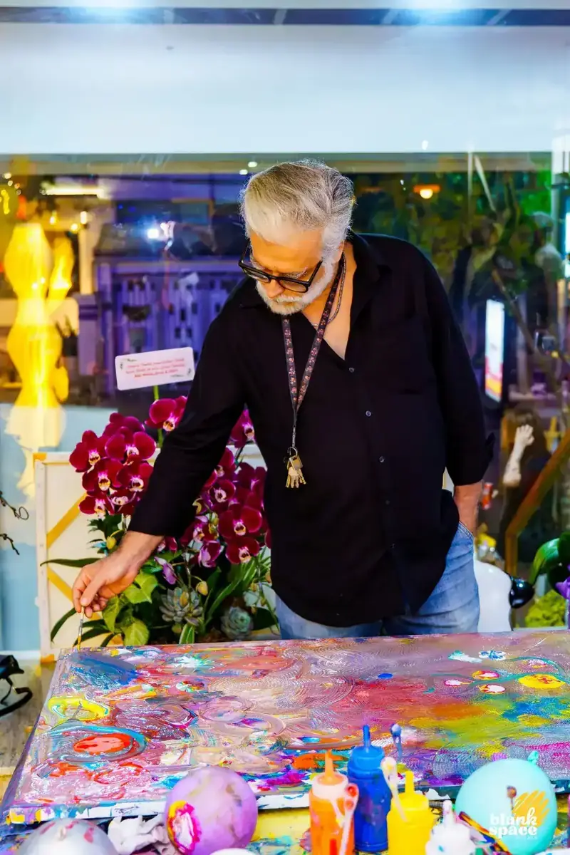 Guest artist creating a painting at a sip and paint night in Saigon