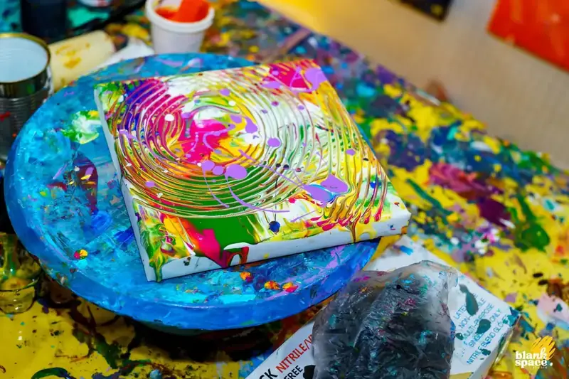 Colorful spin art canvas with rainbow swirls from a kids party in HCMC