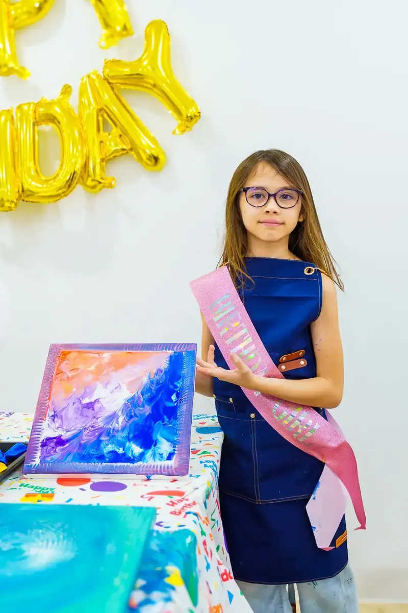 Birthday girl with her paint pour creation at a party in Ho Chi Minh City