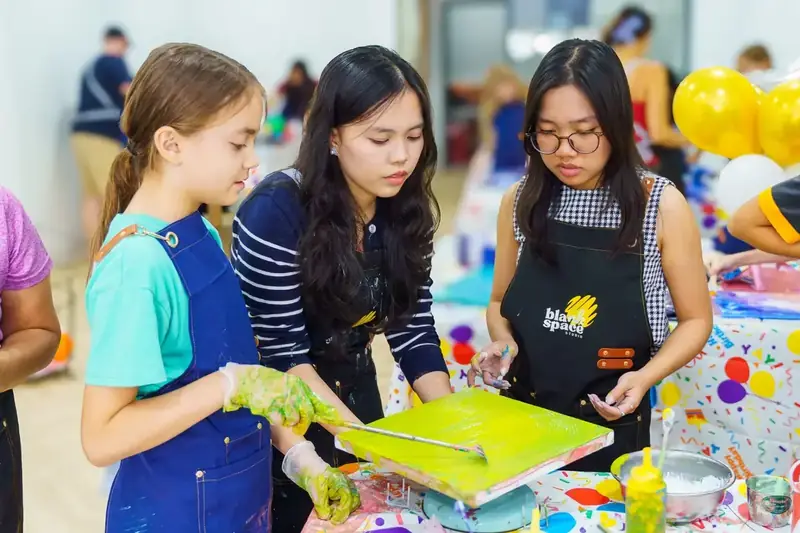 Bright yellow paint pour canvas from an art session near Thao Dien