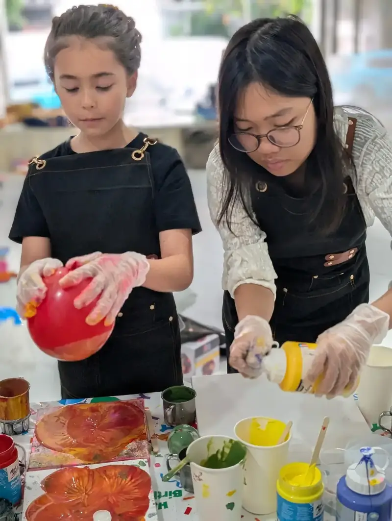 Guests creating colorful paint pouring art at Blank Space Studio Saigon