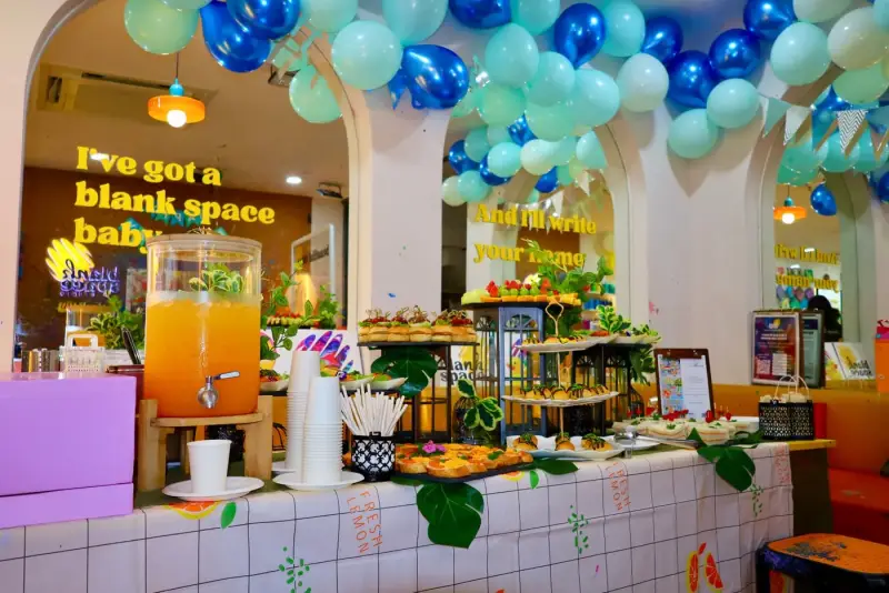 Drinks dispenser and catering under a balloon arch at a private studio event in Ho Chi Minh City