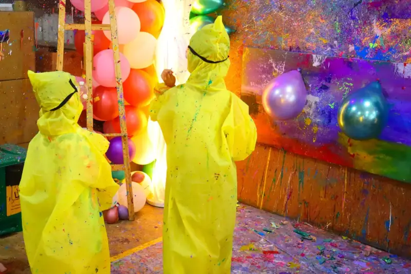 Kids throwing paint darts at balloons in the private studio at Blank Space Studio Saigon