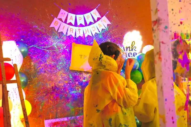 Kids in ponchos in the private splatter room at Blank Space Studio Saigon
