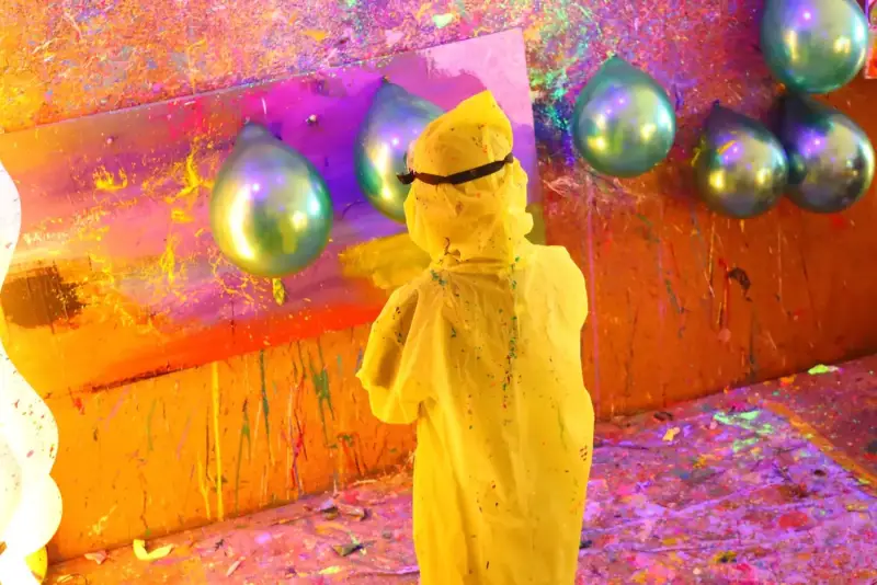 Child in a poncho at the splatter wall in the private studio at Blank Space Studio Saigon