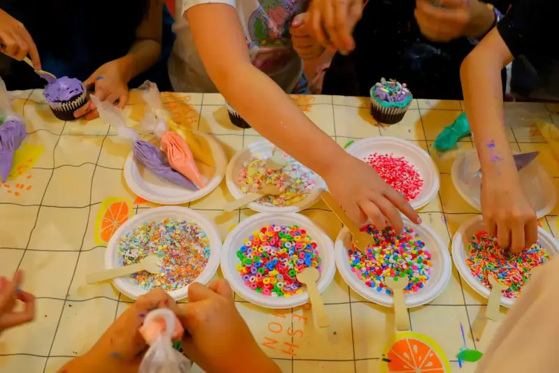 Sprinkles and icing set out for cupcake decorating at a private studio event