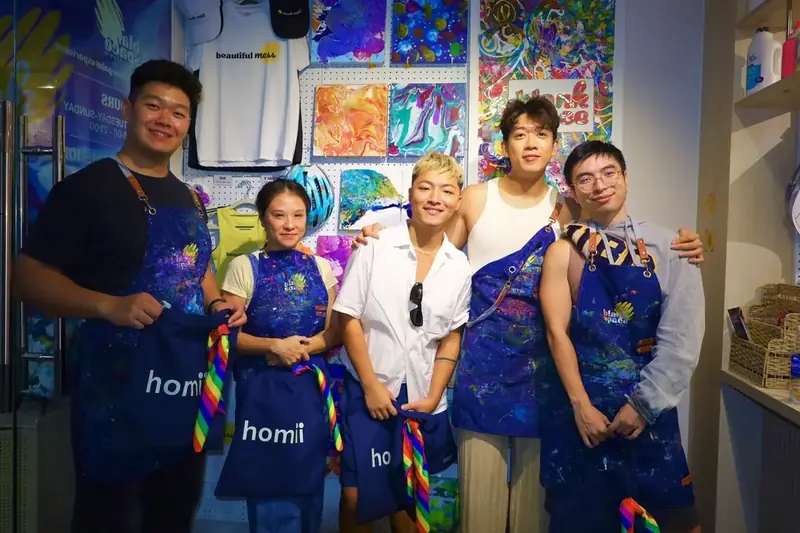 Group in aprons celebrating after a BYOB paint night near Thao Dien