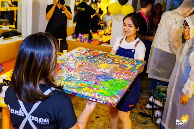 Staff presenting collective artwork at a creative team event in Saigon