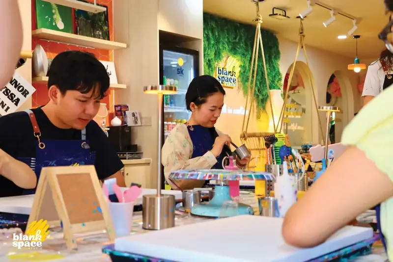 Guests pouring paint during a team bonding session in Saigon