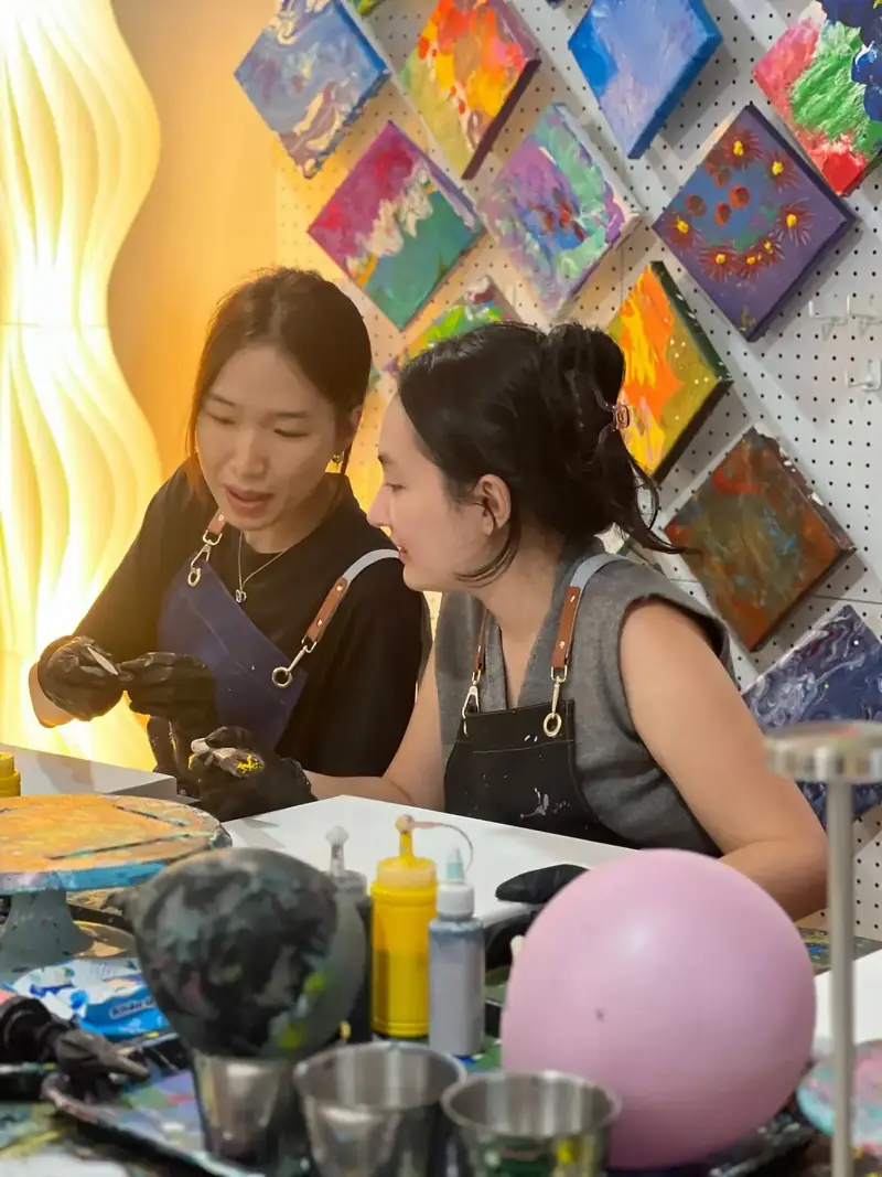 Two colleagues creating art at a corporate team bonding activity in HCMC