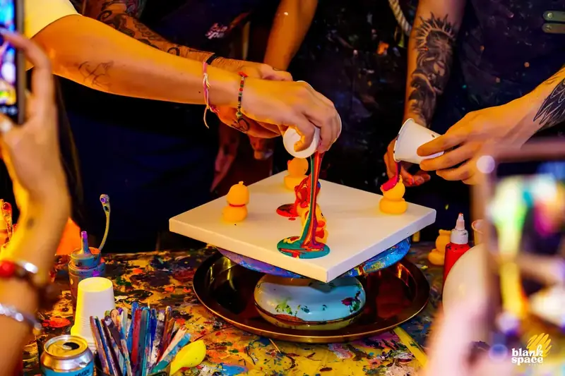 Pouring paint over ducks art piece at a corporate event near Thao Dien
